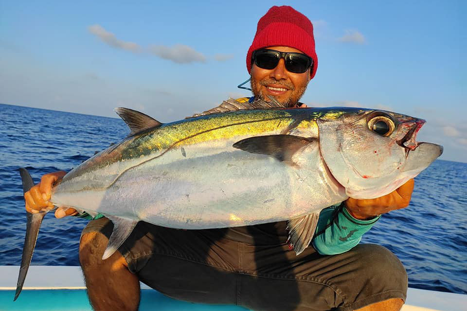 Enjoying a traditional Maldivian fishing trip at sunset, catching fish using hand-line
